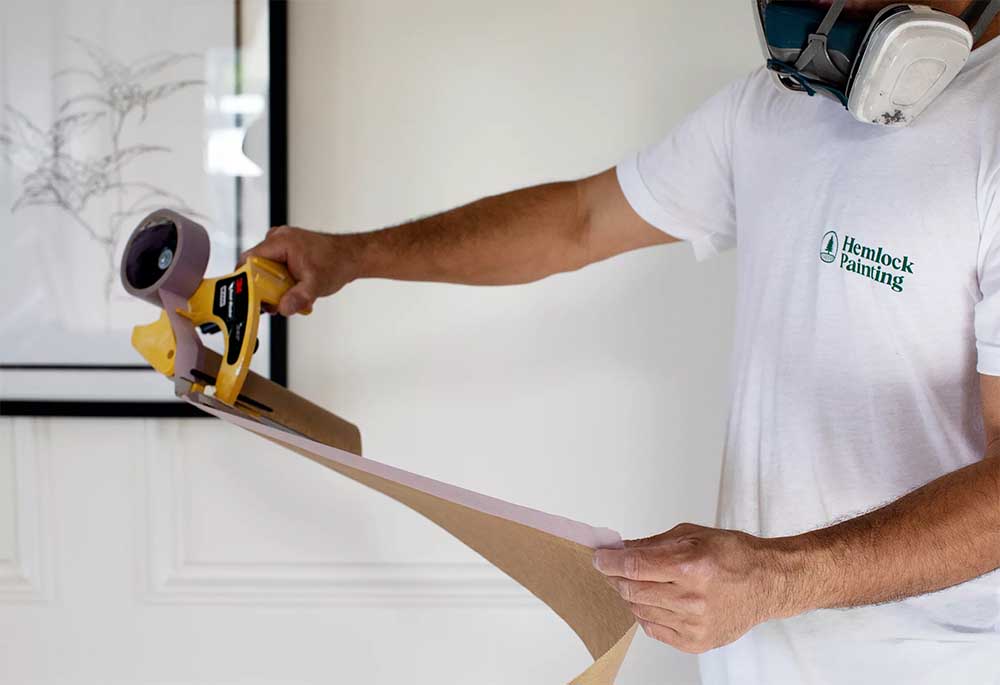 One of Hemlock's exterior painters prepares to protect surfaces before painting a home.